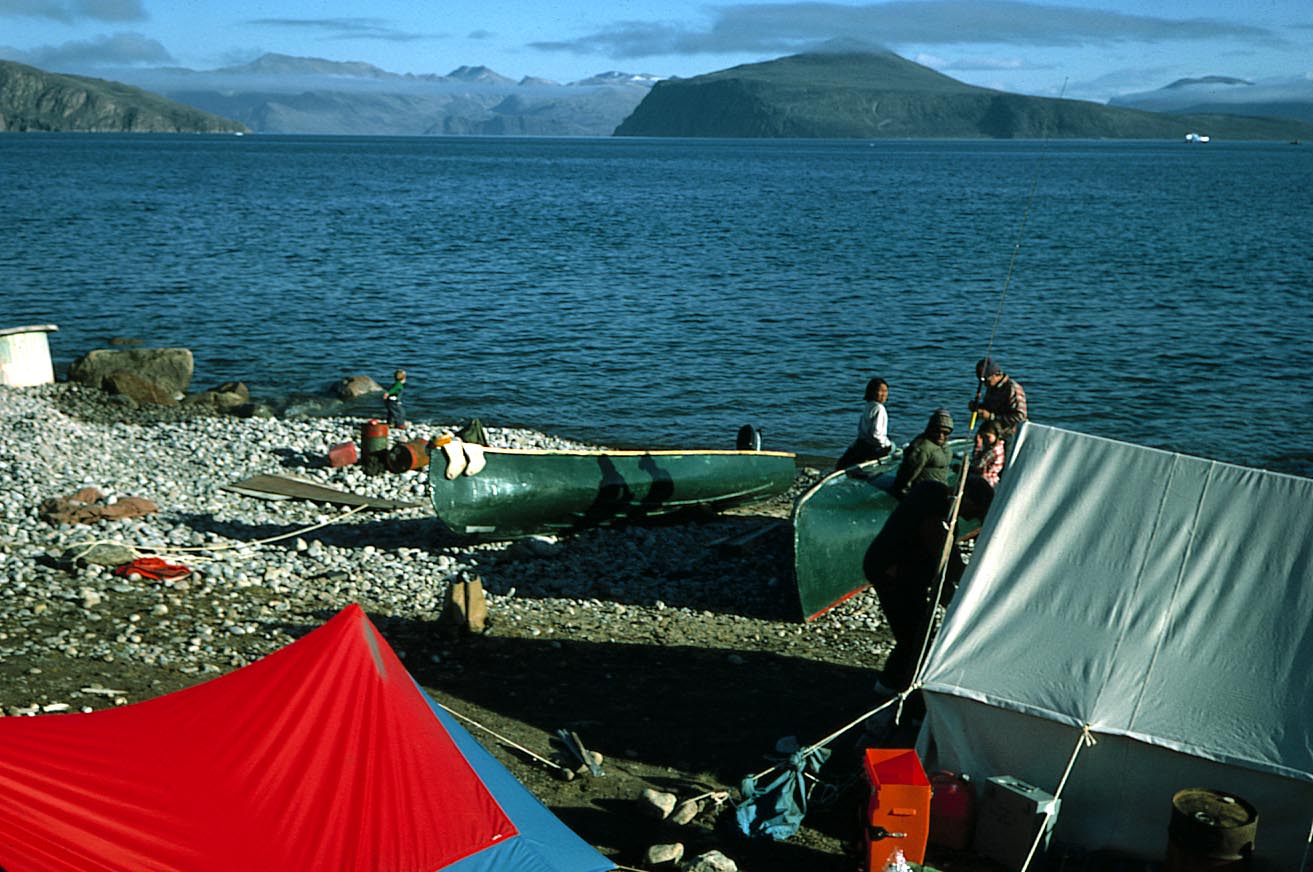 Canoes and tents on a cobbly beach during fieldwork at Qivitu, Baffin Island, 1975