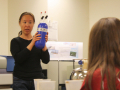 Wei Wang shows an air bottle to students before they conduct an atmospheric experiment. Photo by Shelly Sommer, April 2014.