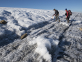 Gifford Miller and Simon Pendleton walk the line separating ancient Pleistocene (lower level) ice, which never melted in the early Holocene warm times, from the younger Holocene ice that overlies it and only accumulated after 5000 years ago. Photo by Matthew Kennedy of Earth Vision Trust.