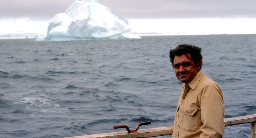 John at the rail of a ship overlooking an iceberg
